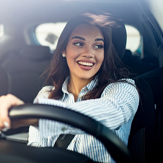 Foto ilustrativa de mulher dirigindo um carro